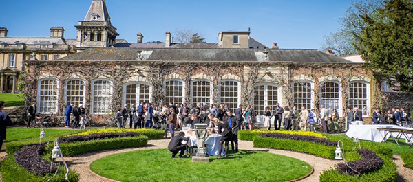 Weddings guests mingle with drinks in the formal gardens outside the Orangery function room.